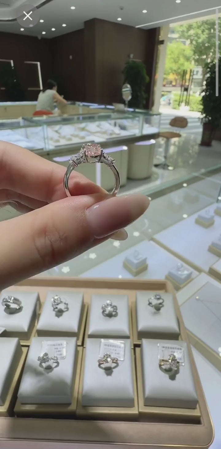 On the hand at the source store's live stream in China - the same pink diamond, before its voyage to Canada